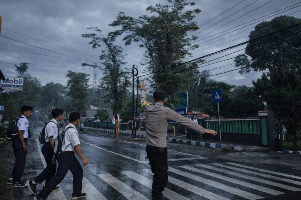 Poros Pagi, Polisi Sigap Seberangkan Siswa di Depan SMPN Senduro