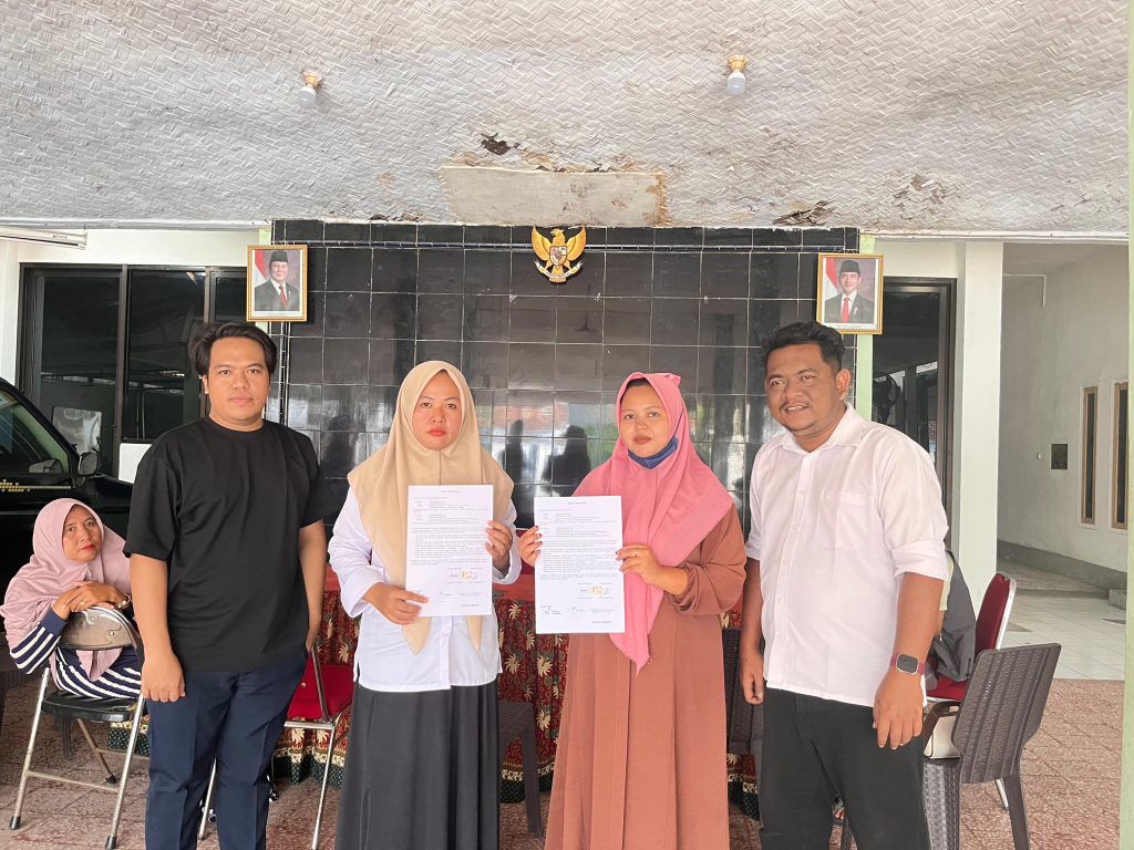 Korban pengrusakan rumah tampak mengenakan kerudung warna pink saat menunjukkan surat kesepakatan damai hasil mediasi yang difasilitasi Pemerintah Desa Gesang, Kecamatan Tempeh.