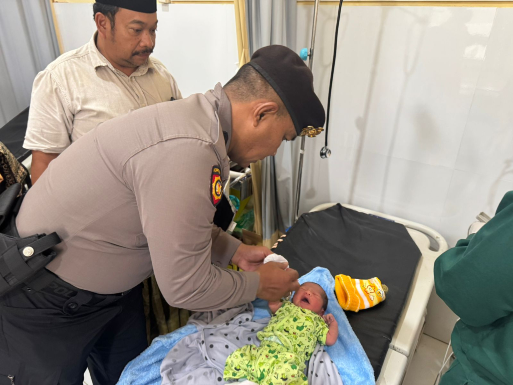 Anggota Polsek Senduro mengevakuasi bayi yang ditemukan