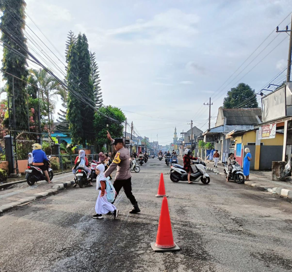 Anggota ketika menyebrangkan pelajar sekolah