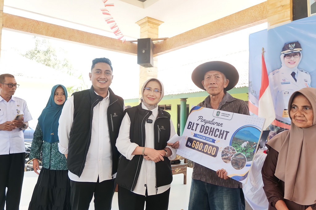 Bupati Lumajang Indah Amperawati bersama Wakil Bupati Yudha Adji Kusuma menyerahkan BLT DBHCHT kepada warga penerima manfaat dalam rangkaian kegiatan Setor Madu di Kantor Desa Yosowilangun Kidul