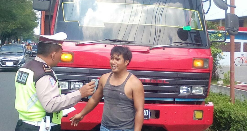 Polisi sedang memperingatkan sopir truck angkutan barang